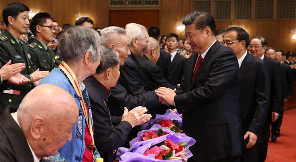 习近平与老红军代表亲切握手,向他们致以崇高敬意