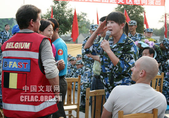 6月1日下午,海政文工团组织艺术家赴四川绵竹灾区慰问演出。图为闫学晶向比利时救援人员敬礼。中国文联网 彭宽 摄