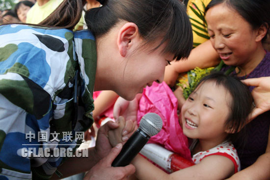 6月1日下午,海政文工团组织艺术家赴四川绵竹灾区慰问演出。图为闫学晶与灾区孩子把手紧紧握在一起。中国文联网 彭宽 摄